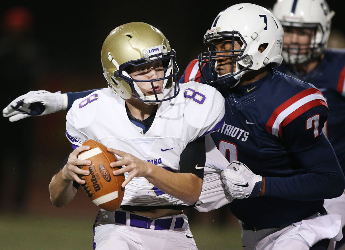 Queen Creek ALA's Donovan Hanna (7) snares the jersey of fleeing Sabino quarterback Alex Bell (8). Mike Christy/Arizona Daily Star